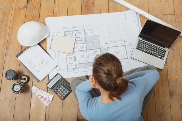 設計図を広げる建築家の後ろ姿