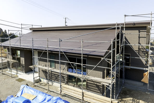 足場が組まれた工事中の平屋建築